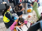 LONDON, ENGLAND - AUGUST 26: Home Secretary Priti Patel (2nd left) talking to Malalai Hussiny (wearing green headscarf) a refugee from Afghanistan who arrived on a evacuation flight at Heathrow Airport on August 26, 2021 in London, England. Ministry of Defence figures put the number of people evacuated by the UK since August 13 at 9,226, but there are thousands feared to be remaining. Foreign Secretary Dominic Raab has said the UK will use "every hour" left to evacuate people from Afghanistan as he declined to rule out British troops having to leave by the end of Friday. (Photo by Dominic Lipinski - WPA Pool/Getty Images)