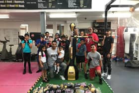 Spabar CEO Jazz Gill with Leamington Community Boxing head coach Babs Kandola, the donated equipment, and the members of one of the club's youth classes.