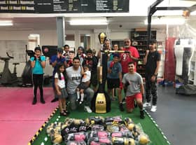 Spabar CEO Jazz Gill with Leamington Community Boxing head coach Babs Kandola, the donated equipment, and the members of one of the club's youth classes.