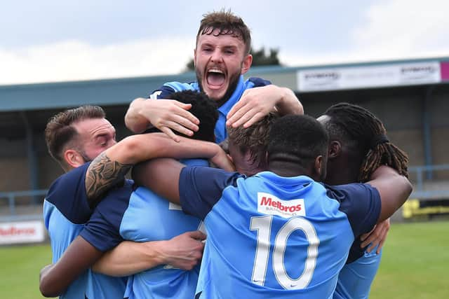 Liam Francis is mobbed after heading in Rugby's second goal