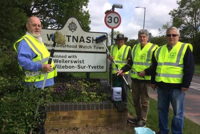 Tony Heath cleaning the Whitnash sign
