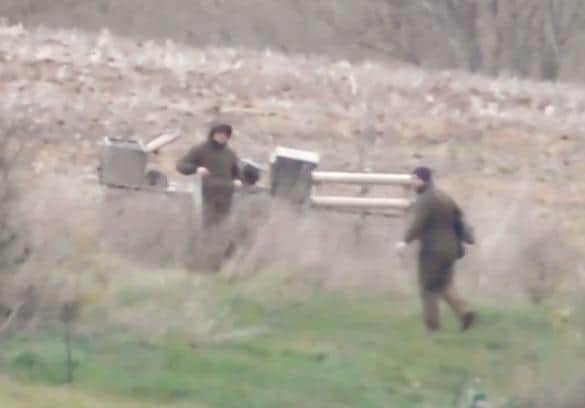 Saboteurs filming the incident say the man on the right had retrieved the fox body which was partially concealed inside a coat