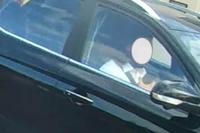 This driver has been banned from driving for six months after a member of the public filmed him using his phone at the wheel in Leamington. Police have covered his face.