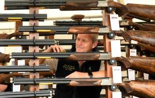 Gary Bowles from The Oxford Gun Company ensures their stock of shotguns look their best on their stand.