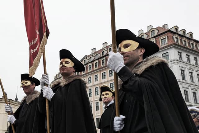 The costumed parade makes its way through the city