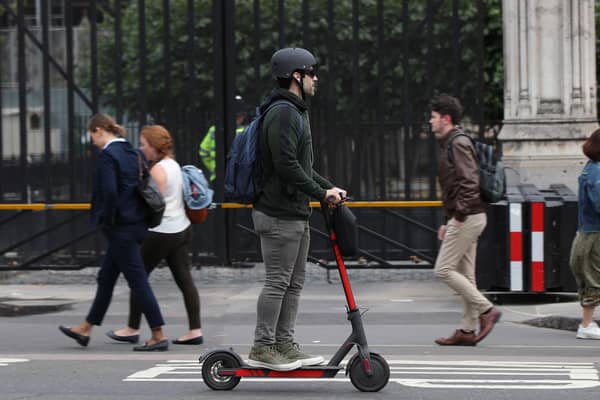 A person riding an electric scooter in Westminster, London.