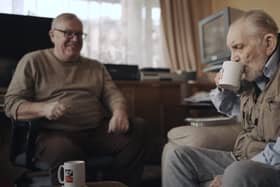 Volunteer Liam (left) with blind veteran Ken enjoying a cup of tea and a chat