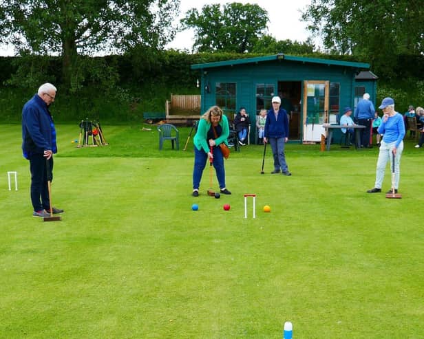 Guests enjoying a game, tea and cake in the background