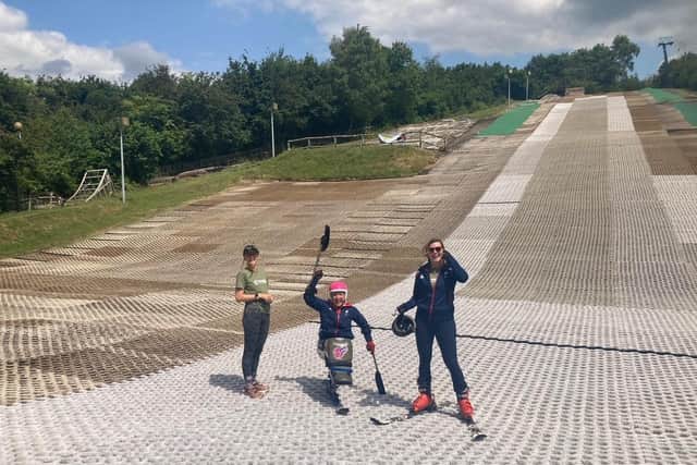 Anna Turney on the dry ski slope at Ackers Adventure, with Running Out of Time support team members either side. Picture supplied.