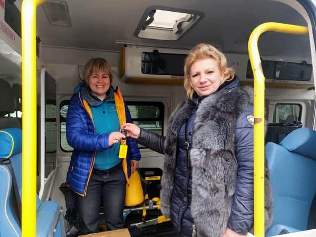 The ambulance being delivered to Ukraine civilians near Zaporizhzhia. From left to right: Roxanne Litynska, the British-based volunteer driver, and Sviltlana, the Ukrainian civilian, receive the ambulance keys in Ukraine. Photo supplied
