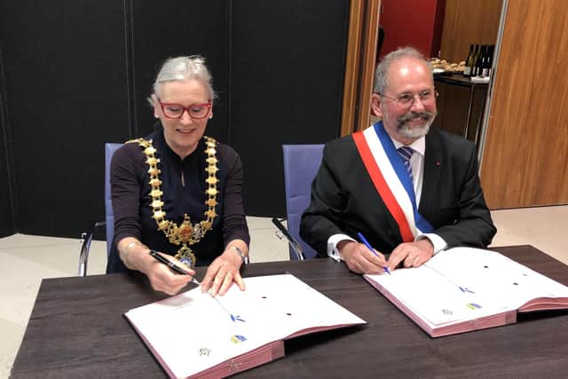 Philippe Laurent and Susan Rasmussen signing the vows of friendship between the two towns. Picture submitted.