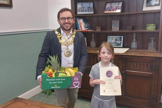 Ella Border from Aylesford School receiving her prize from the Mayor of Warwick Cllr Richard Edgington. She was a joint winner with ‘The Crowns of Coten End’ team from Coten End Primary School, who were both in the five to nine age category. Photo supplied