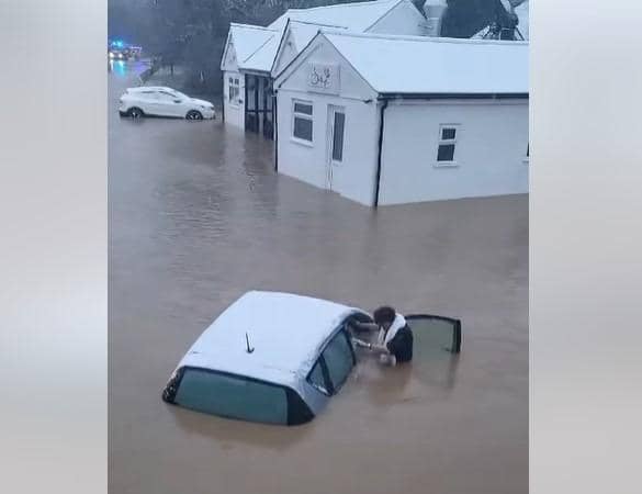 Woman is pulled from car during heroic flood rescue