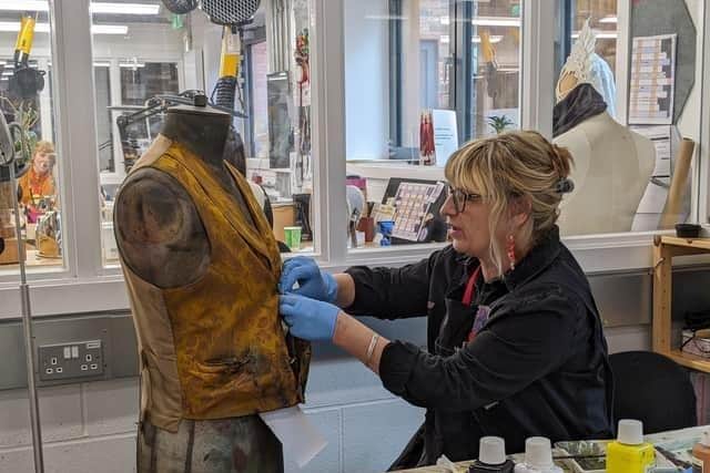 Jenny Cowgill of Leamington ensures the waistcoat of Old Joe looks suitably worn and dirty. Photo supplied