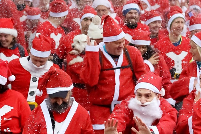 The Myton Hospice’s famous Santa Dash at Victoria Park, Leamington Spa, Warwickshire, a 5K festive charity fun run with around 1300 Santa's. December 10, 2023.  See SWNS story SWNAsanta.