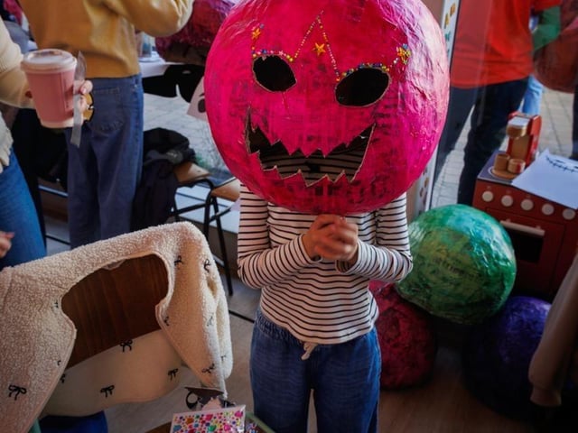 Someone wearing one of the handmade pumpkin heads.