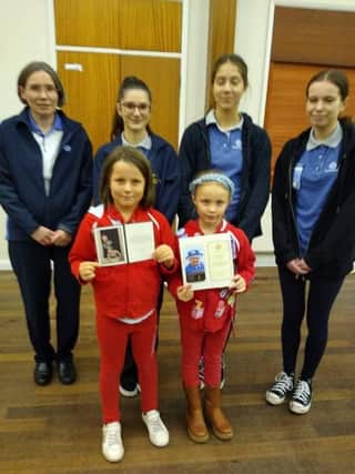 Members of The St Marks Rainbow Guides show off their letters from the late Queen Elizabeth and her son King Charles