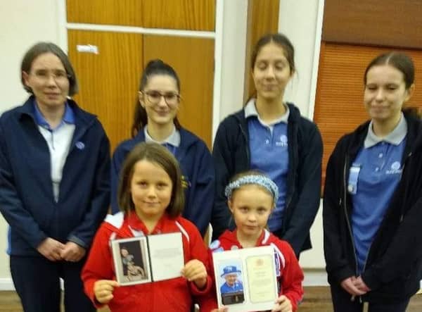 Members of The St Marks Rainbow Guides show off their letters from the late Queen Elizabeth and her son King Charles