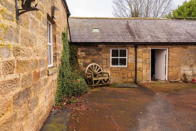 The property includes a handy stone outbuilding, a timber car port and three garages.