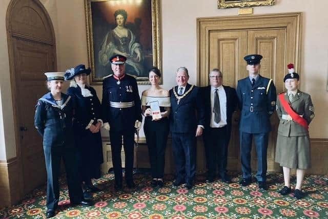 Elizabeth Baitson (fourth from left) being presented with her British Empire Medal by Lord Lieutenant Tim Cox, alongside local dignitaries including the High Sheriff of Warwickshire, Sophie Hilleary, Chairman of the County Council, Councillor Chris Kettle, and the Lord Lieutenant’s cadets. Photo supplied