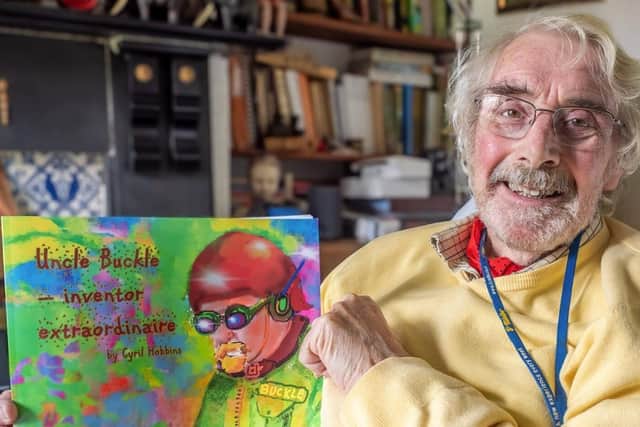 Cyril Hobbins in 2024 with his children's picture book Uncle Buckle: inventor extraordinaire. Picture supplied.