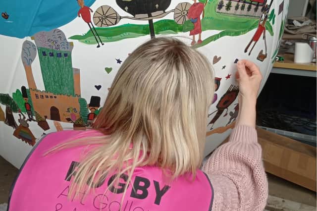 Fit for a Queen - Joanne Bailey, arts development officer at Rugby Art Gallery and Museum, puts the finishing touches to the giant rugby ball sculpture set to be unveiled in the town centre ahead of next month's Platinum Jubilee bank holiday weekend.