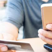 A person looks at their bank card and mobile phone. PIC: Alamy/PA