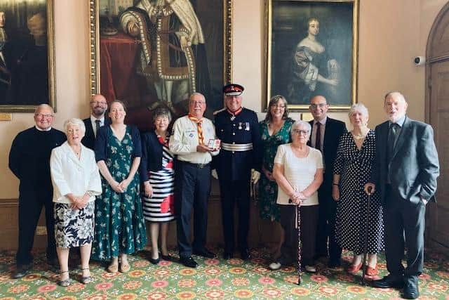 Douglas Shorter (centre) being presented with his British Empire Medal by Lord Lieutenant Tim Cox, alongside family and friends. Photo supplied