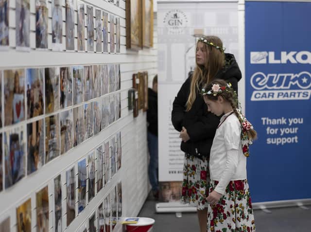 Youngsters look at the wall at the Aid for Ukraine shop in Leamington, which has messages of thanks from children in the war-torn country. Picture submitted.