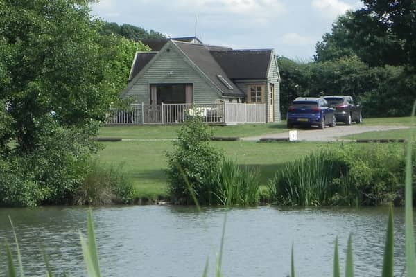 The Skylark Lodge at Brook Meadow viewed from across the campsite's five-acre fishing lake