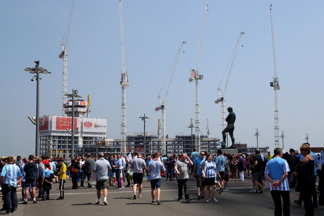 Construction cranes can be seen as fans make their way past the Bobby Moore statue before the Sky Bet League Two Play Off Final between Coventry City and Exeter City at Wembley Stadium on May 28, 2018.
