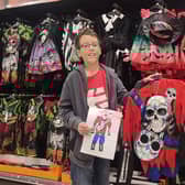 Étienne holding his costume and his design in Tesco. Photo supplied