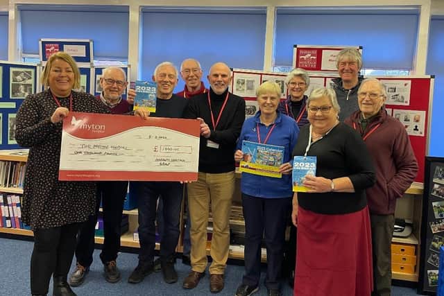 The cheque for £1,000 being presented inside the Heritage Centre, in the grounds of Harbury Primary School, to Myton’s community fundraising officer Louise Careless (left), with members of the Heritage Group committee and some of the artists. Picture supplied.