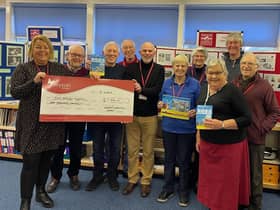 The cheque for £1,000 being presented inside the Heritage Centre, in the grounds of Harbury Primary School, to Myton’s community fundraising officer Louise Careless (left), with members of the Heritage Group committee and some of the artists. Picture supplied.