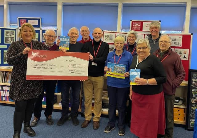 The cheque for £1,000 being presented inside the Heritage Centre, in the grounds of Harbury Primary School, to Myton’s community fundraising officer Louise Careless (left), with members of the Heritage Group committee and some of the artists. Picture supplied.