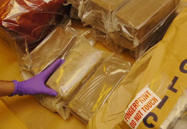 A member of staff at the Forensic Science Service in London examines part of a 33 kg haul of heroin seized by the Metropolitan Police. The heroin is being examined to aid police officers in their investigation surrounding the haul. 