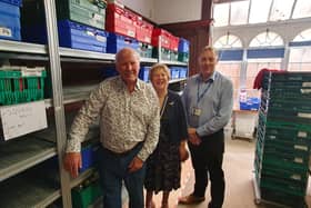 Rotarians Edward Binns and Kate Lawrence, with Adi Robinson, at the foodbank.