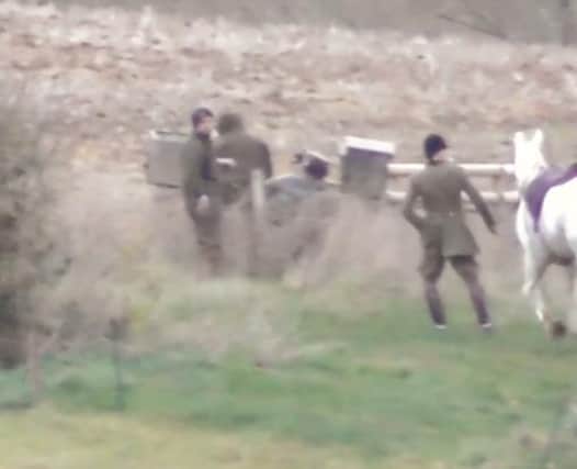The body of the fox is put into a box on a quad bike, while the huntsman looks on, according to hunt saboteurs