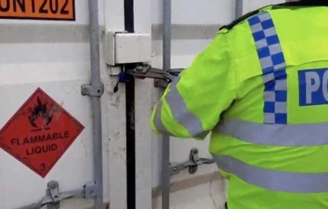 A police officer forces entry on a trailer at the quarry in Finmere