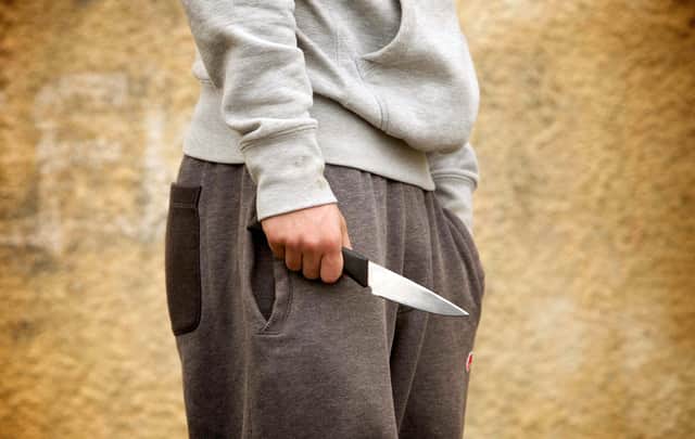 PICTURE POSED BY MODEL. A youth with a knife, as the number of people carrying knives has fallen to a nine-year low, according to the figures released by the Government in a Parliamentary answer to Nationalist backbencher Stuart McMillan.
