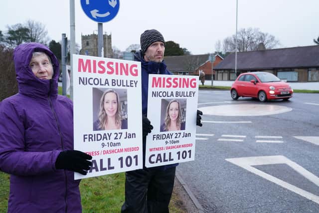Friends of missing woman Nicola Bulley hold missing person appeal posters along the main road in St Michael's on Wyre on Friday morning.