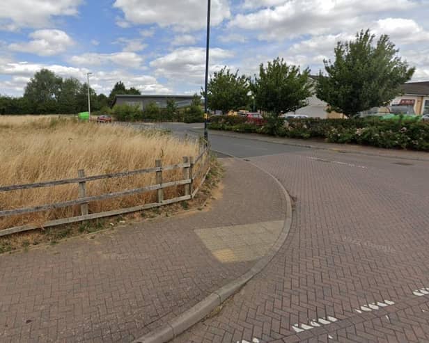 The area to the left of the access road to Cawston's shops has not attracted the hoped-for GP surgery or other community resource so a decision is due on plans to put houses there instead. Photo: Google Street View.