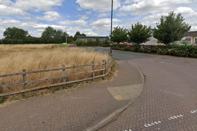 The area to the left of the access road to Cawston's shops has not attracted the hoped-for GP surgery or other community resource so a decision is due on plans to put houses there instead. Photo: Google Street View.