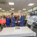 Saqib Bhatti MP shaking hands with Stuart Croft after a ceremonial cutting of cake