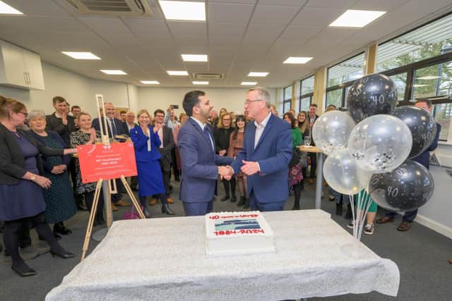 Saqib Bhatti MP shaking hands with Stuart Croft after a ceremonial cutting of cake