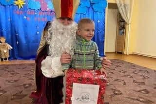 Little Davyd receiving the Christmas gift from David Harrop on Christmas morning in the monastery where he now lives cared for by the Sisters of Saint Joseph in central Ukraine. Picture supplied.