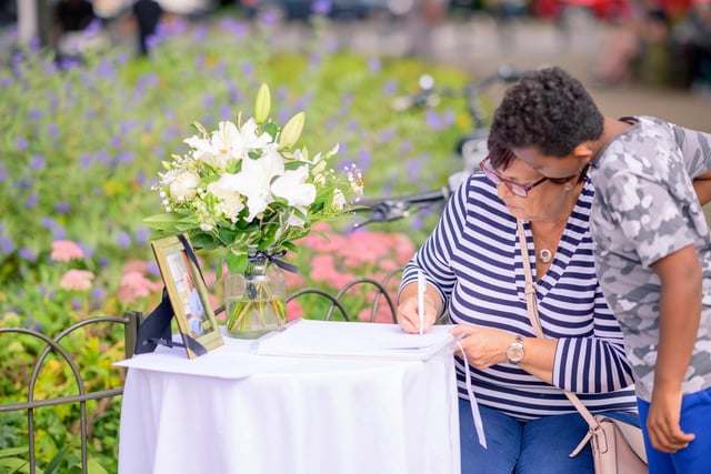 Festival visitors signing the book of condolence for the Royal Family.