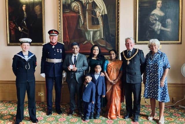 Aby Joseph (third from left) being presented with his British Empire Medal by Lord Lieutenant Tim Cox next to family and friends. Photo supplied