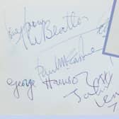 The Beatles autographs with a blurry 'George' inset.