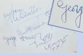 The Beatles autographs with a blurry 'George' inset.